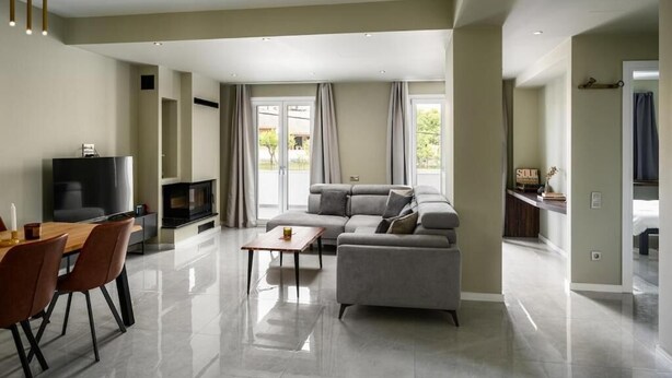 A spacious living area with a sofa, TV, and dining table. - Comme a la maison (Alepou)