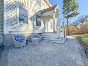 A house with a covered porch, outdoor seating, and a landscaped yard. - Spacious 4BR Portland Retreat 4 King Beds + BBQ (Westbrook)