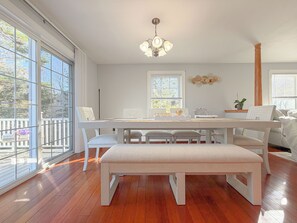 A spacious dining area with a long table, benches, and a chandelier. - Spacious 4BR Portland Retreat 4 King Beds + BBQ (Westbrook)
