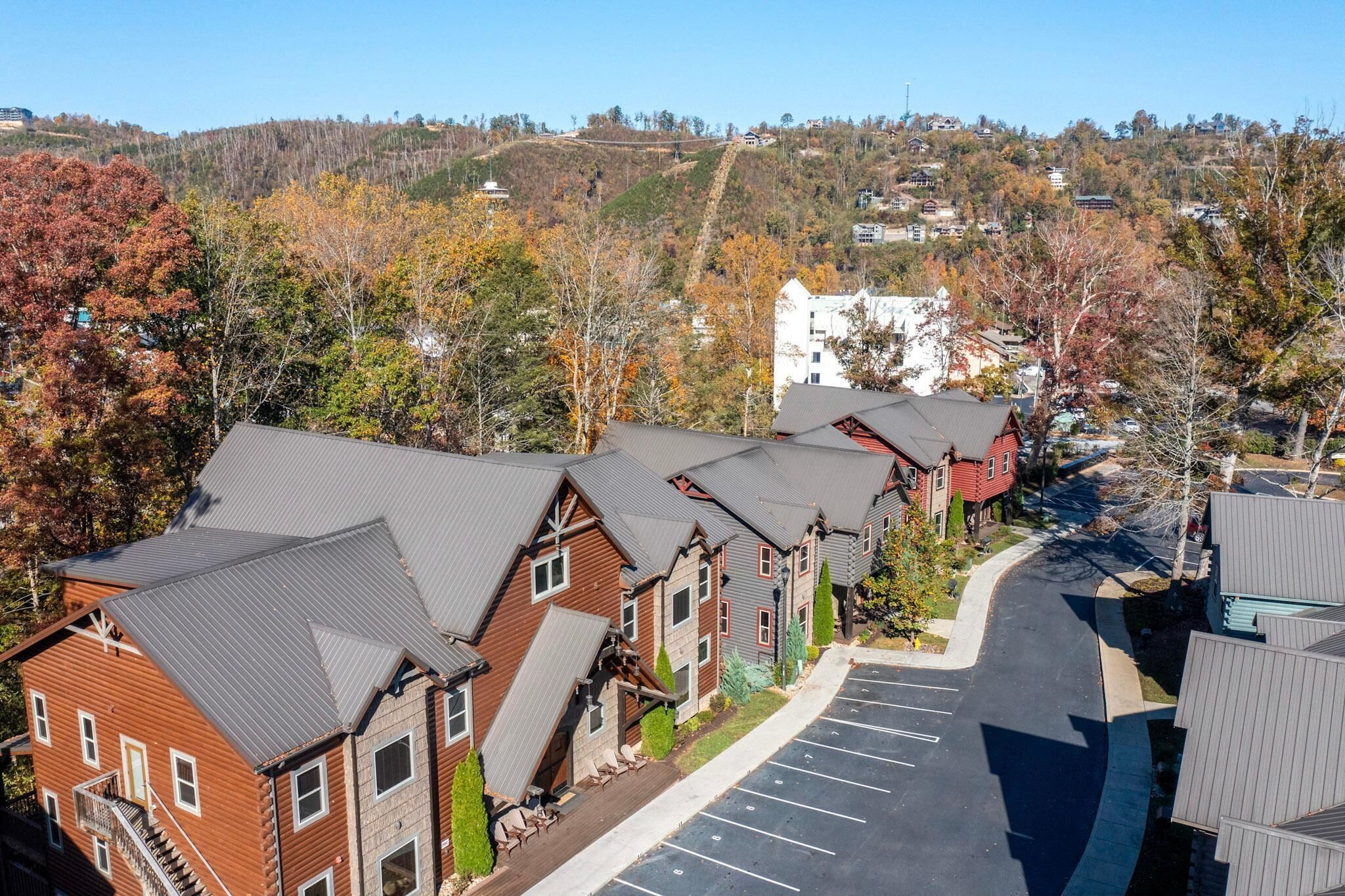 A row of log cabin-style buildings with a parking lot in front.