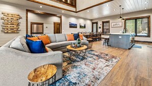 A spacious living area with a sofa, coffee table, and dining area. - Splash Villa (Pigeon Forge)
