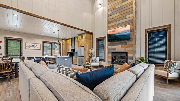 A spacious living area with a sofa, dining table, and kitchen in the background. - Splash Villa (Pigeon Forge)