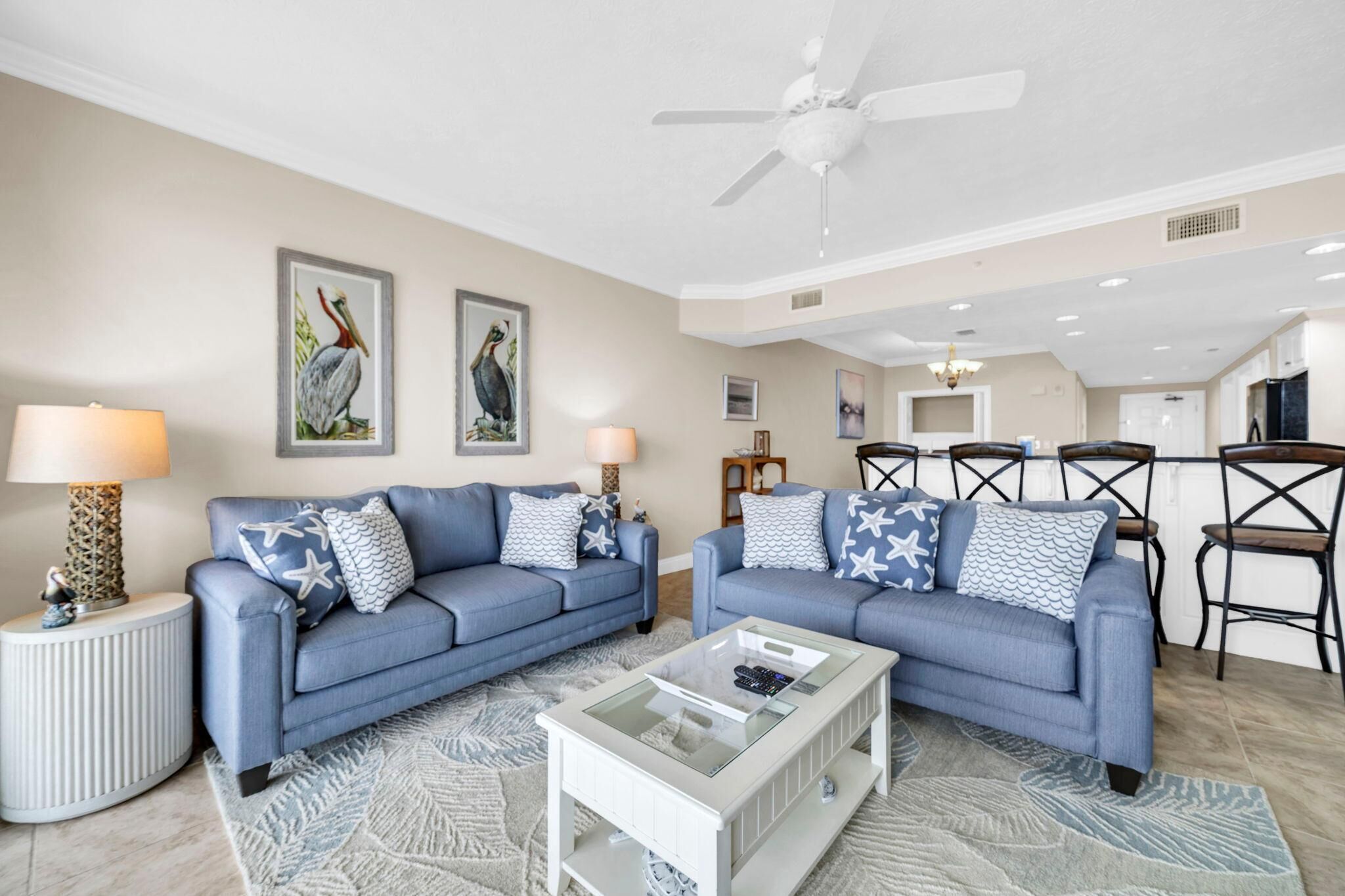 A living room with two sofas, a coffee table, and a ceiling fan.