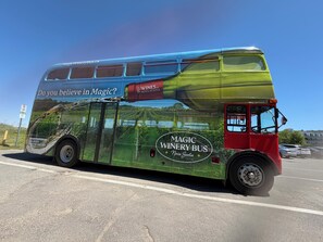 Kaksikerroksinen bussi, jonka kyljessä on teksti ”MAGIC WINERY BUS” ja mainos ”WINES OF NOVA SCOTIA”.