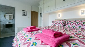 Et hotelværelse med seng, badeværelse og skab.