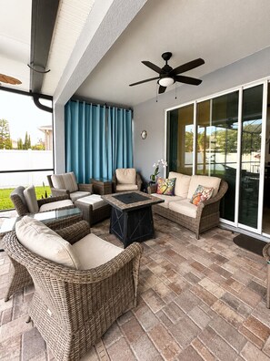A covered patio with wicker furniture, a ceiling fan, and a glass door leading outside. - Tampa Sunshine Oasis / Heated Saltwater Pool / 4Bed, 3Bath / Sleeps 10 / Fenced (Tampa)