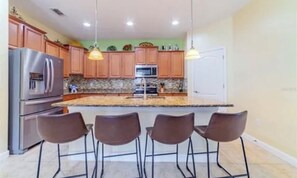 A modern kitchen with granite countertops, stainless steel appliances, and wooden cabinets. - Tampa Sunshine Oasis / Heated Saltwater Pool / 4Bed, 3Bath / Sleeps 10 / Fenced (Tampa)