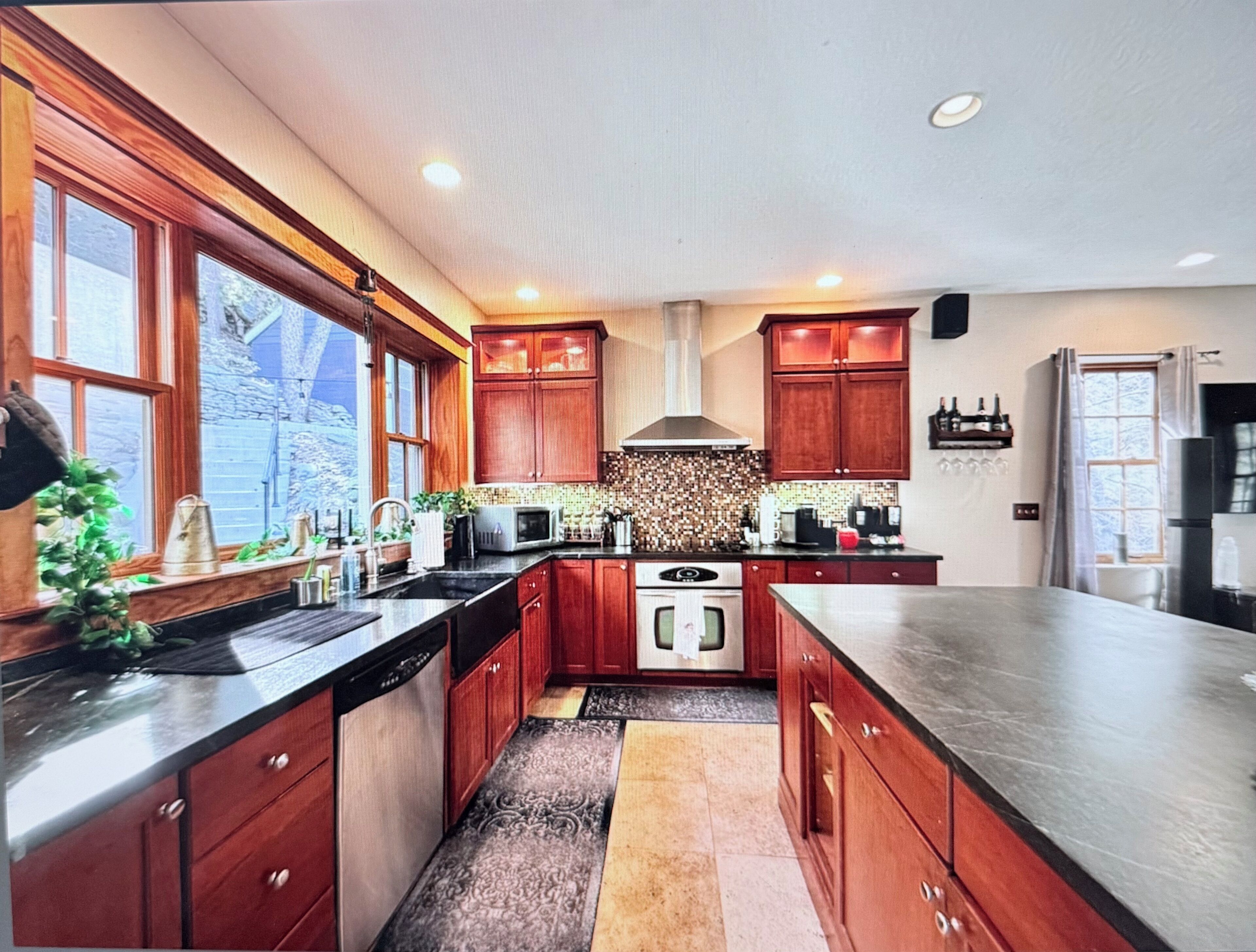 A modern kitchen with wooden cabinets, stainless steel appliances, and a large island.. Luxury 4-bedroom Mountain Home with Game room. Pet friendly