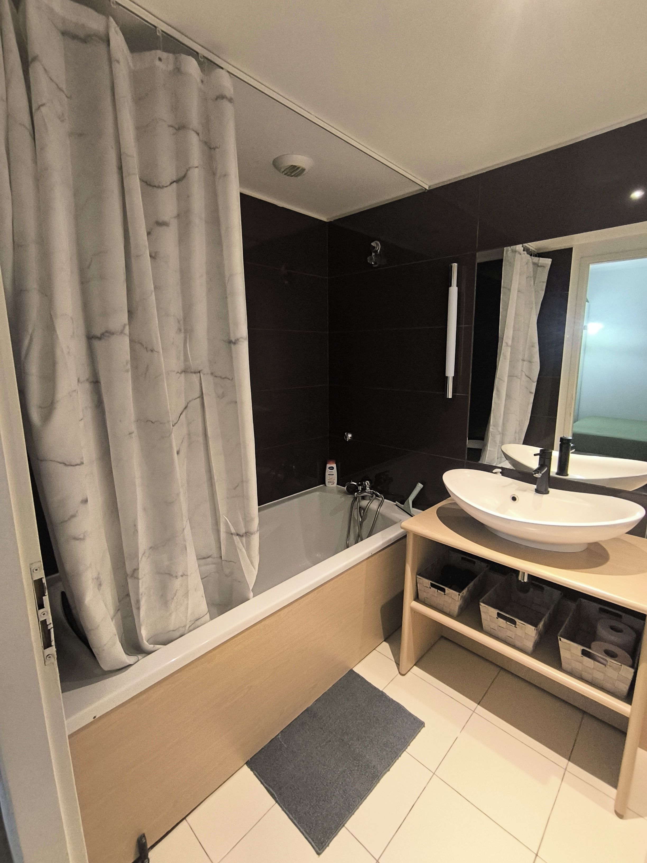 Une salle de bain moderne avec une baignoire, deux lavabos et un grand miroir.