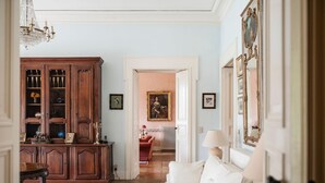 Une pièce avec un meuble en bois, un canapé blanc, un tapis à motifs et un lustre.