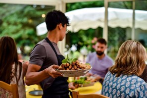 A person serving food to guests at an outdoor event.