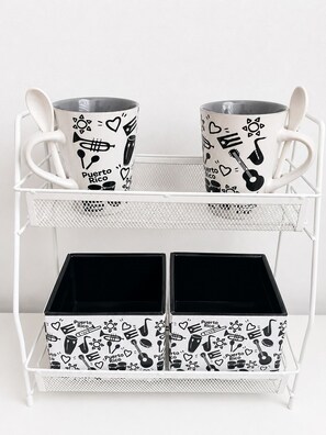 Un estante metálico blanco con dos tazas y dos cajas, todos con diseños alusivos a Puerto Rico.