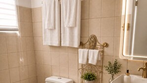 A modern bathroom with a toilet, bidet, sink, and a mirror. - Beautiful 1-bedroom studio with AC in charming Arecibo (Arecibo)
