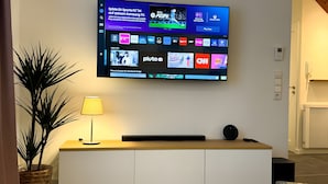 Een flatscreen-tv aan de muur met verschillende zenders en een spelinterface.
