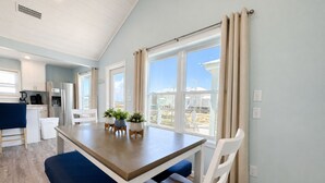 Una cocina moderna con comedor, ventanas amplias y vistas al exterior.