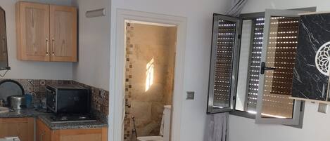 A compact living space with a kitchenette, a dining area, and a bathroom.