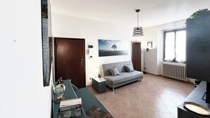 Un salon avec un canapé, une table sur laquelle sont posés des livres, un globe terrestre et un tableau accroché au mur.