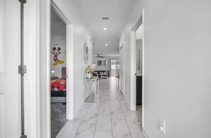 A hallway with a bed, a Mickey Mouse mural, and a dining area. - Spacious 5-bedroom house in soothing Davenport with pool and fitness room (Davenport)