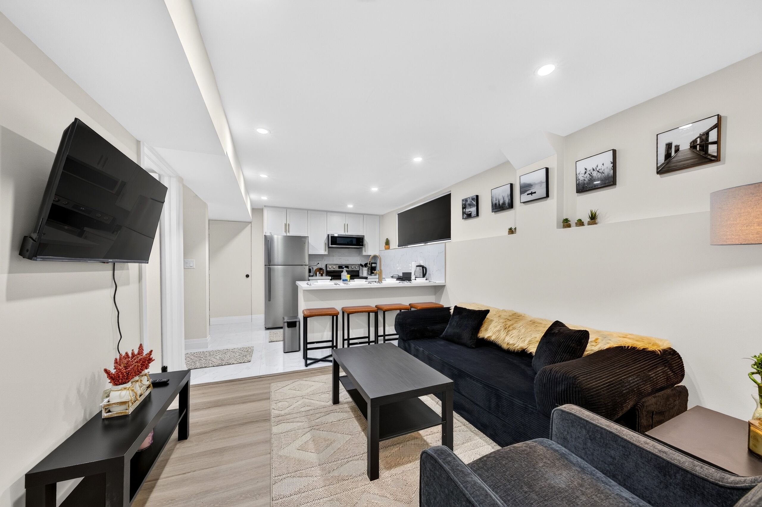 A modern living room with a sofa, a coffee table, and a TV mounted on the wall.