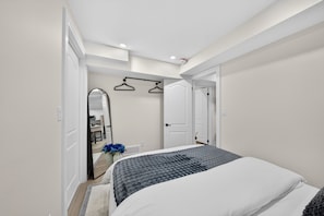 Una camera da letto con un letto, uno specchio, un armadio e una porta che dà su un bagno.