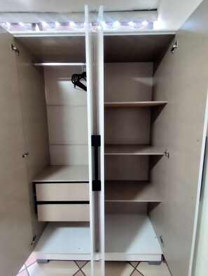 A closet with multiple shelves and drawers, equipped with a light fixture above. - ACCOMMODATIONS IN THE HEART OF OAXACA (Oaxaca de Juárez)