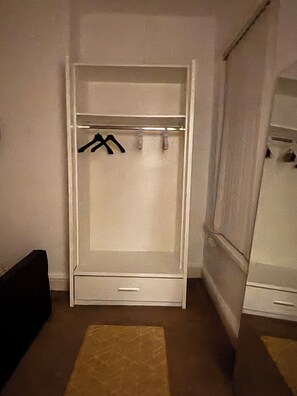 A walk-in closet with a hanging rod and a single drawer. - Spacious 4BR Home | Sleeps 7 | 2 Baths | Long Stays (Manchester)