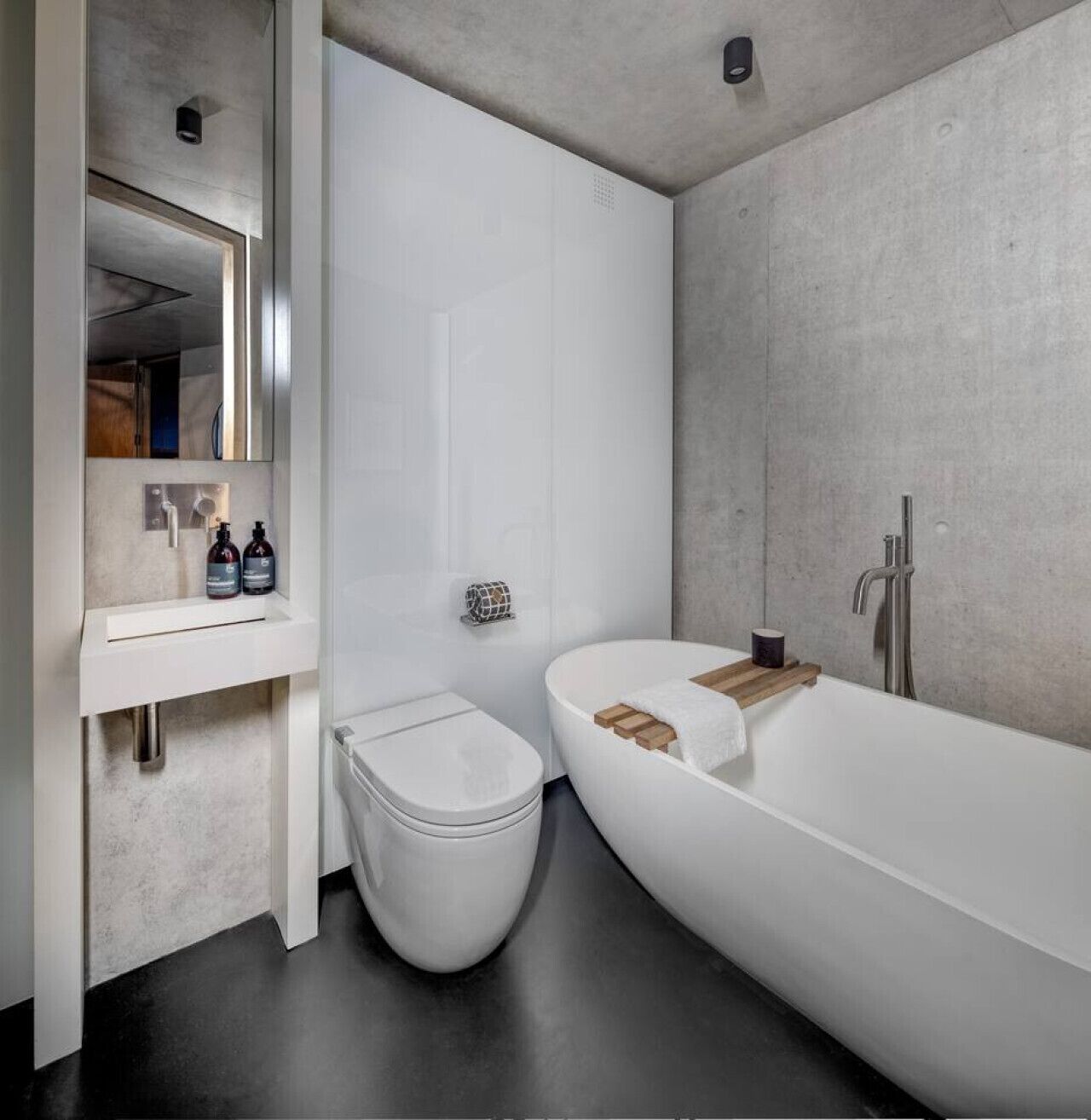 A modern bathroom with a white sink, toilet, and bathtub.