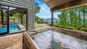 Ein Whirlpool, ein Schwimmbad und Blick auf Wald und Berge.
