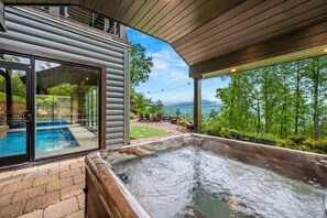 Ein Whirlpool, ein Schwimmbad und Blick auf Wald und Berge.