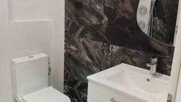 Een douche, handdoeken, toiletpapier