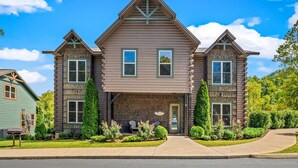 A two-story log cabin with a front porch, two windows on the upper floor, and a door. - The Majestic Pine Retreat (Gatlinburg)