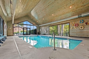 Ein Hallenbad mit Holzboden und -wänden, großen Fenstern und Rettungsringen an der Wand.
