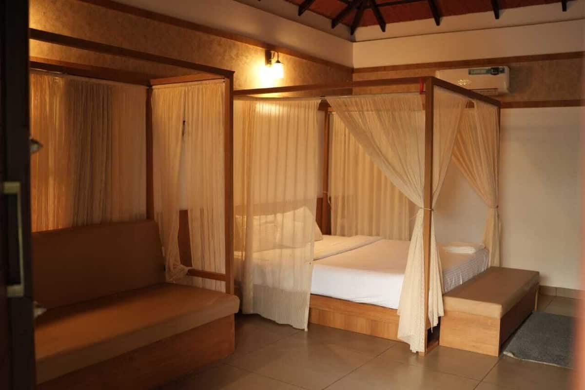 A room with a bed, a bench, and a small table.