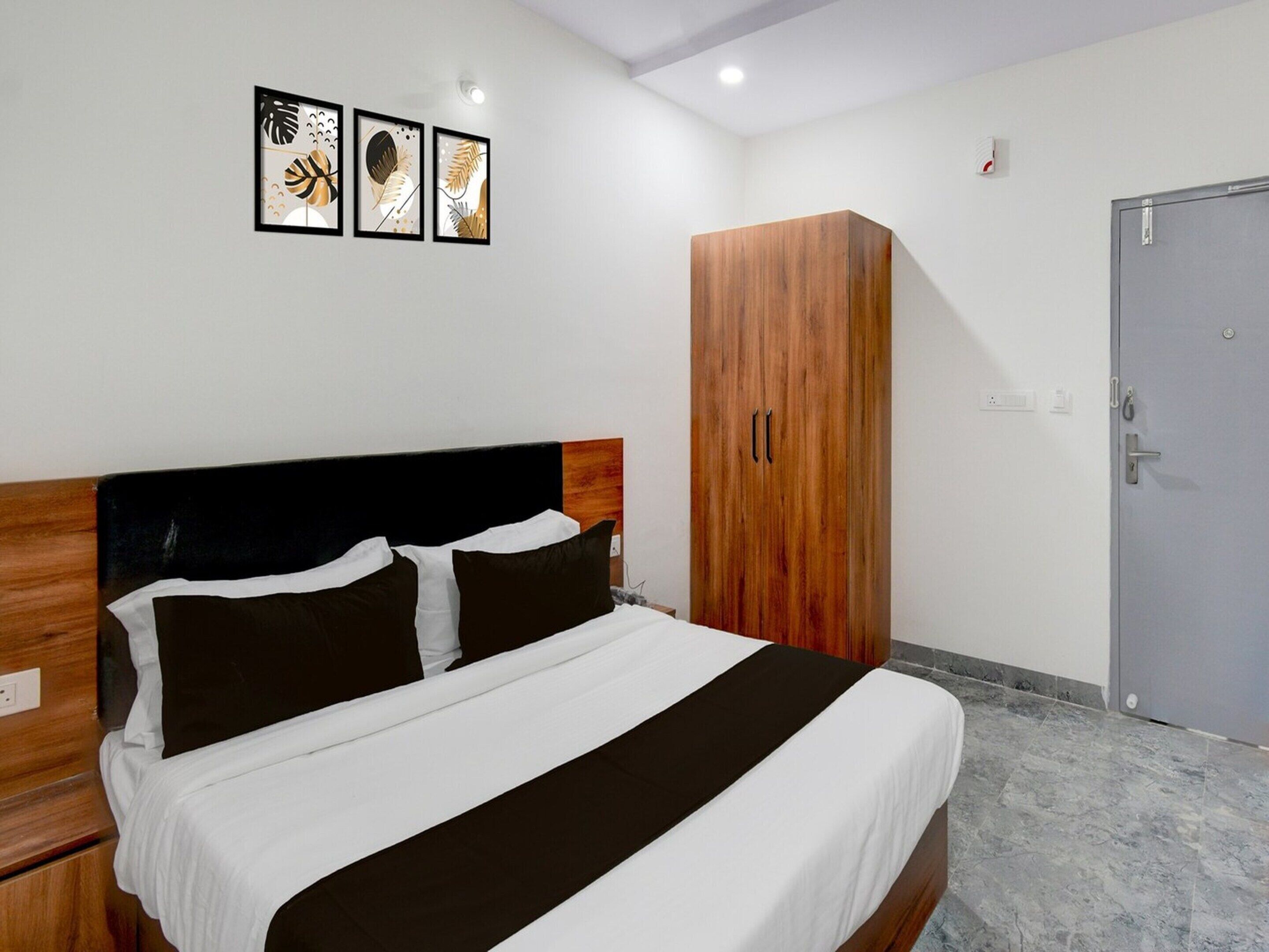 Una habitación de hotel con una cama, un armario y una puerta.