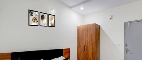Una habitación de hotel con una cama, un armario y una puerta.