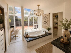 A modern bathroom with a freestanding bathtub, a large window, and a chandelier. - NEW! Lux Sedona Stay • Hot Tub • Views • Game Room (Sedona)
