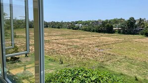 A view from a window overlooking a field with buildings in the distance. - Cozy 1-bedroom bungalow in quaint Polgasowita with AC (Polgasowita)