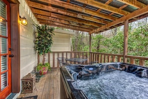 Eine Holzterrasse mit Whirlpool, Sitzgelegenheiten im Freien und einem Blumentopf.