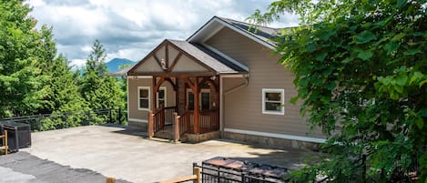 A building with a porch, a covered entrance, and a fenced area with a black gate.