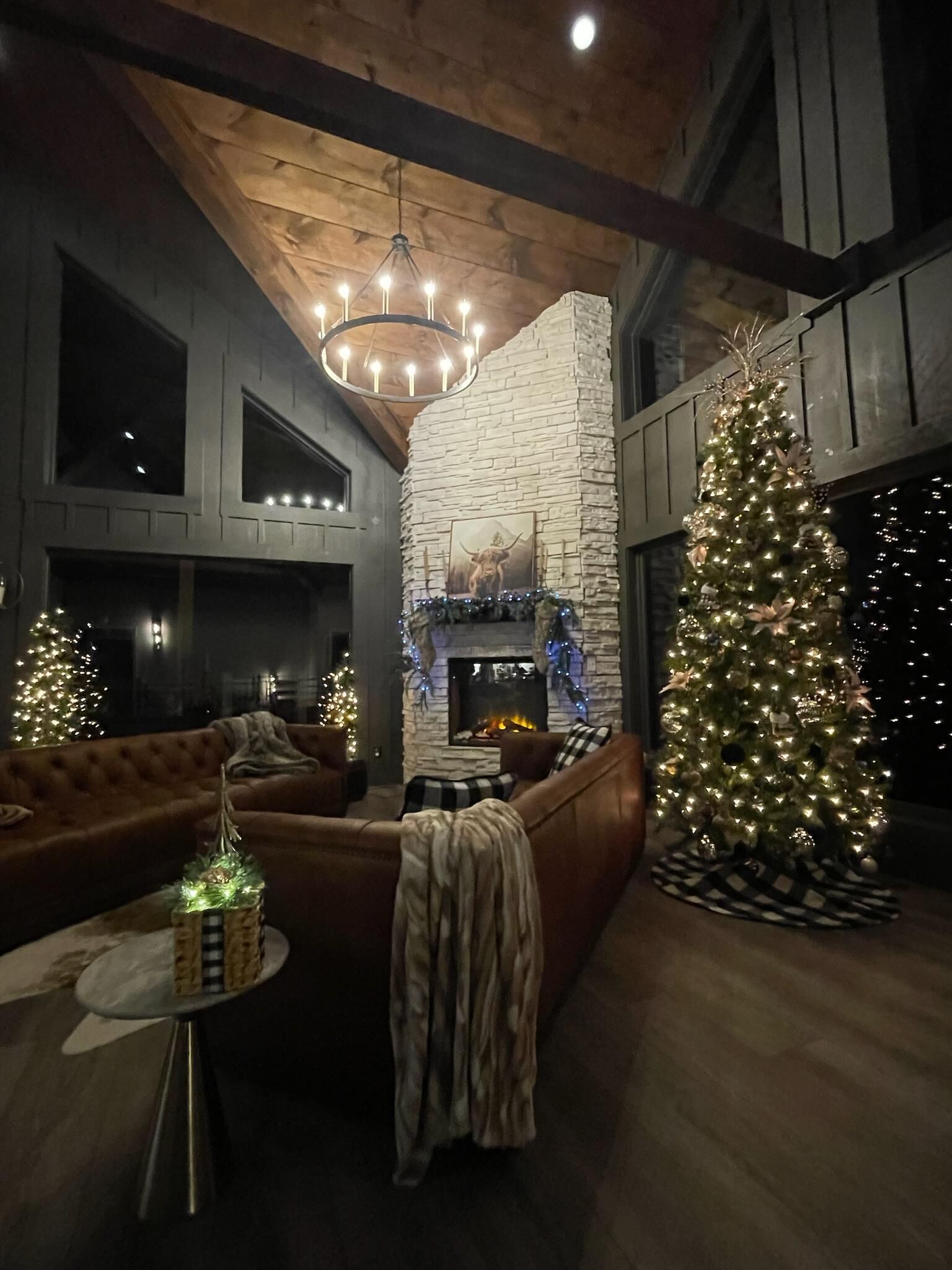 Una sala de estar acogedora con chimenea, un gran árbol de Navidad y un sofá de cuero.