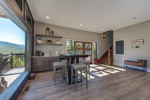 Une cuisine spacieuse dotée d’un grand îlot central, d’un plancher en bois et offrant une vue sur l’extérieur.