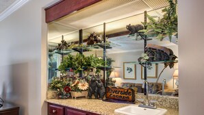 A bathroom with a granite countertop, a sink, a mirror, and a sign that reads 'Riverside Escape'. - Riverside Escape (Gatlinburg)