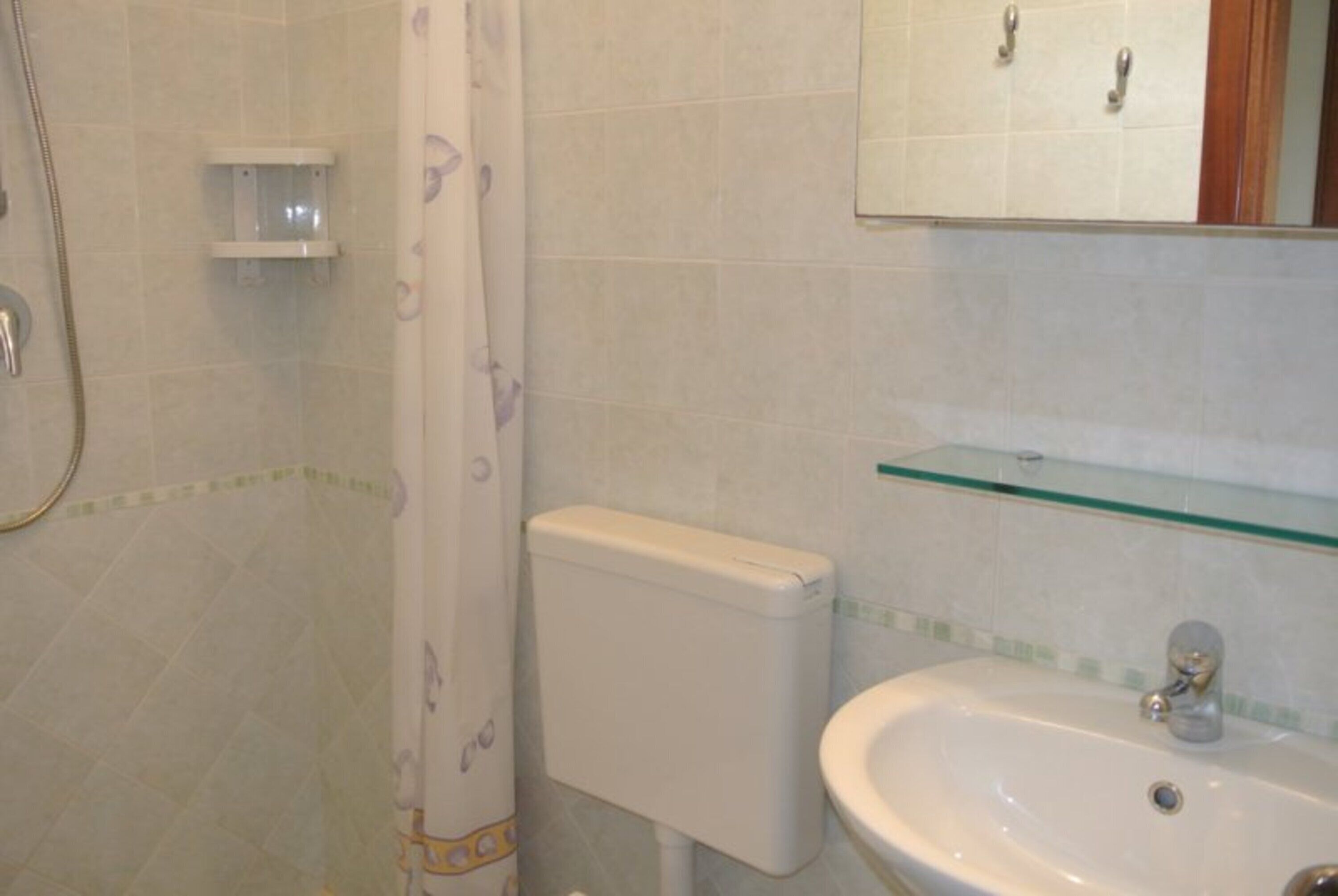 Un baño con ducha, inodoro y lavabo.