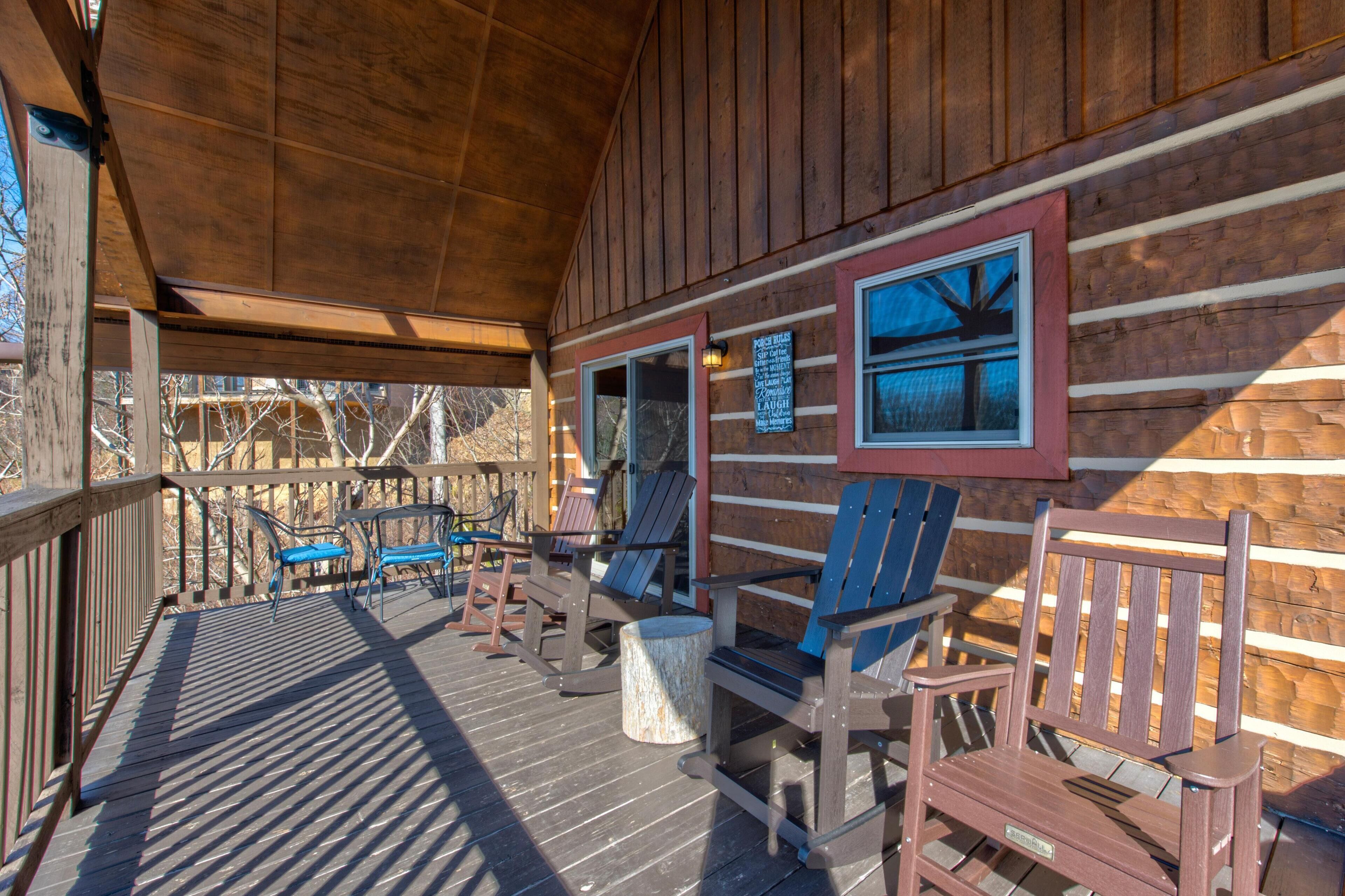 Eine Holzterrasse mit Adirondack-Stühlen und einem Tisch, eine Holzverkleidung mit einem gerahmten Bild und ein Schild mit Text.
