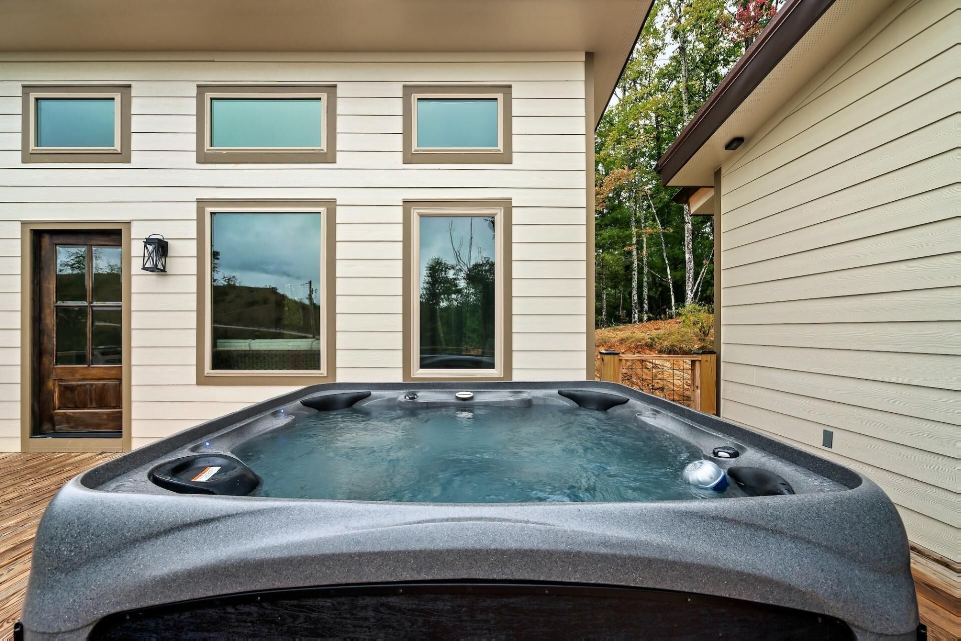 Una casa moderna con un jacuzzi en el patio trasero.