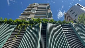 A modern building with vertical green slats, a wooden facade, and the text 'ON THE SEA arpoader'. - Luxury LOFT in Brand New 5★ Building Steps from Ipanema & Copacabana beach (Rio de Janeiro)