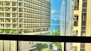 A view from a window with a green sofa, a street, and buildings in the background. - Luxury LOFT in Brand New 5★ Building Steps from Ipanema & Copacabana beach (Rio de Janeiro)