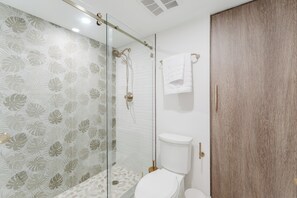 A bathroom with a glass shower enclosure, a toilet, and a wooden wardrobe. - The Cabana - Boca Boutique Pool Suite (Boca Raton)