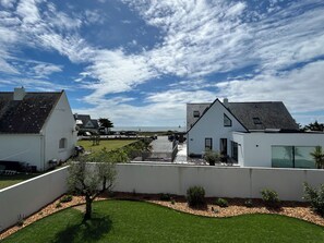 A residential area with white houses, a clear sky, and a view of the sea. - Villa Zoliette (Batz-sur-Mer)