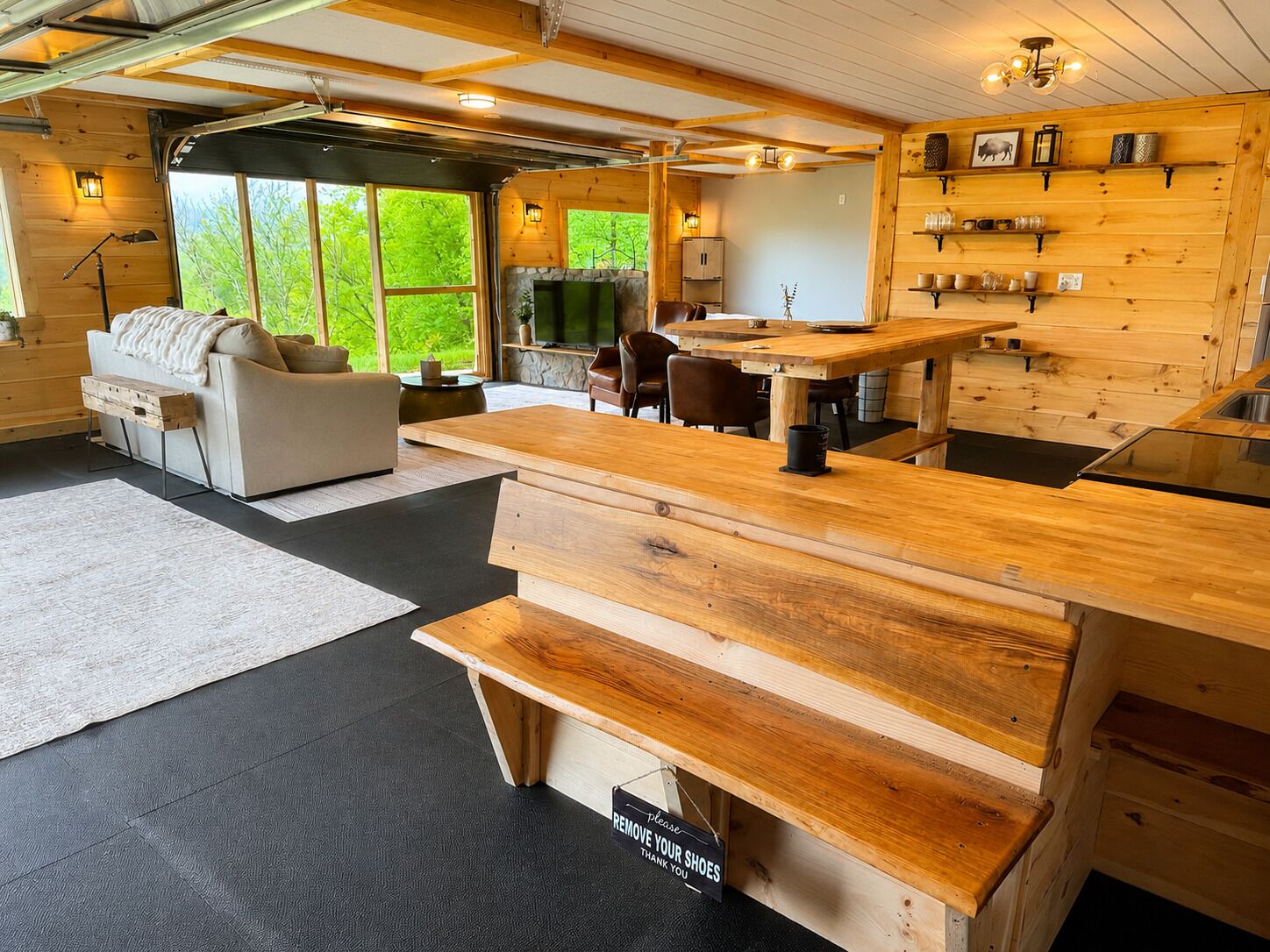 L’intérieur d’un chalet accueillant, avec une table à manger en bois, un canapé et une cheminée en pierre.
